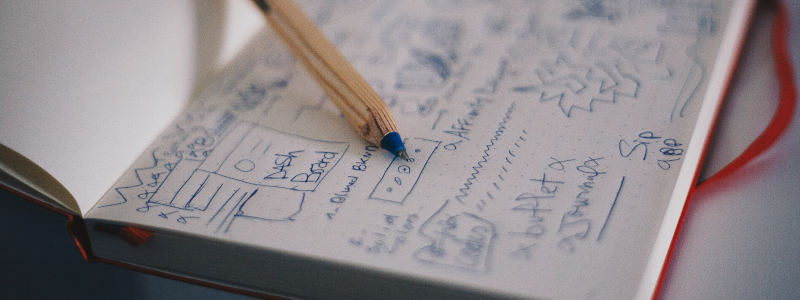 Photo of a pen on top of handwritten plans