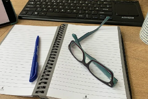 Notebook, pen, keyboard and glasses
